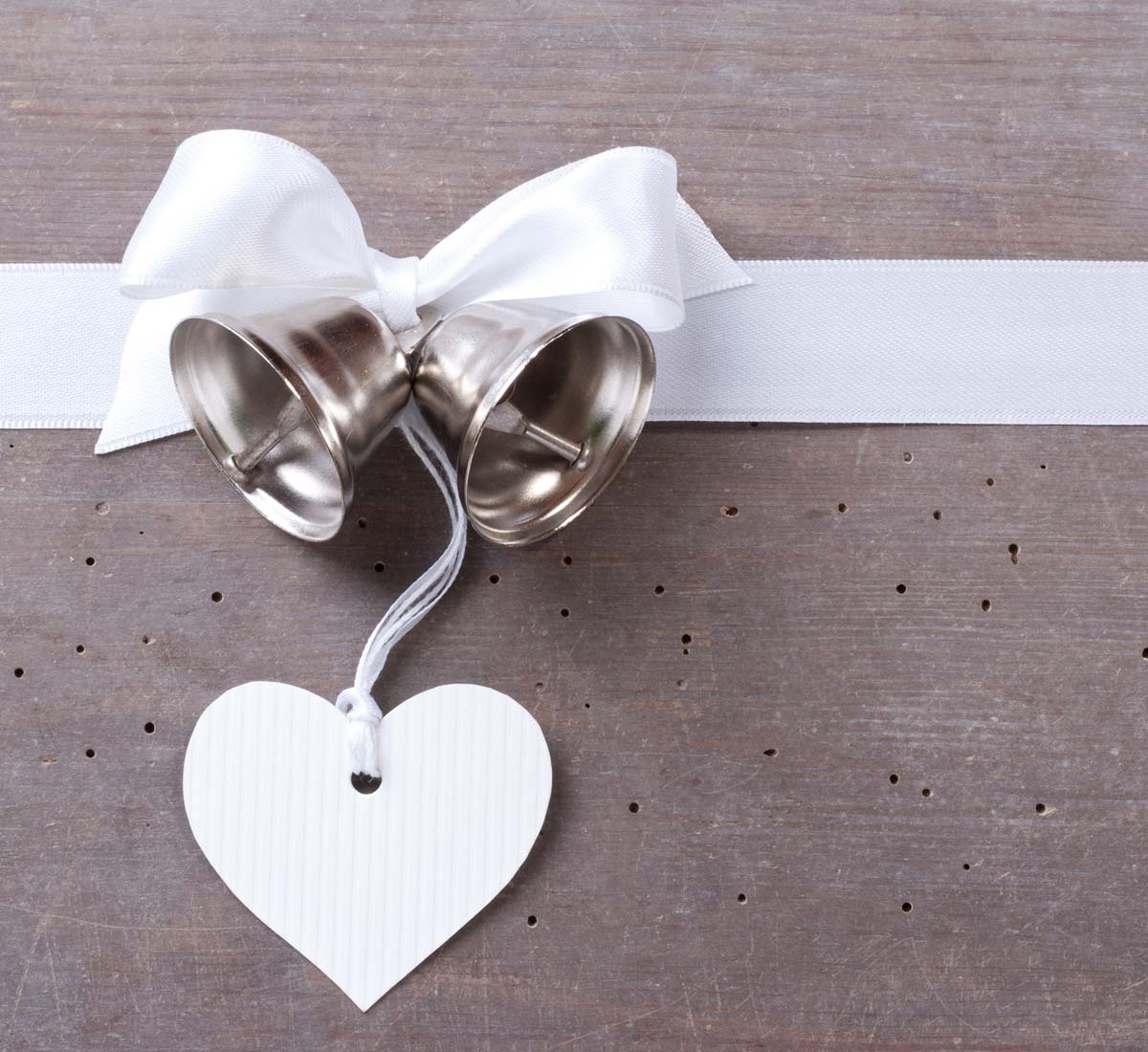 tiny silver wedding bells with white ribband and white paper heart