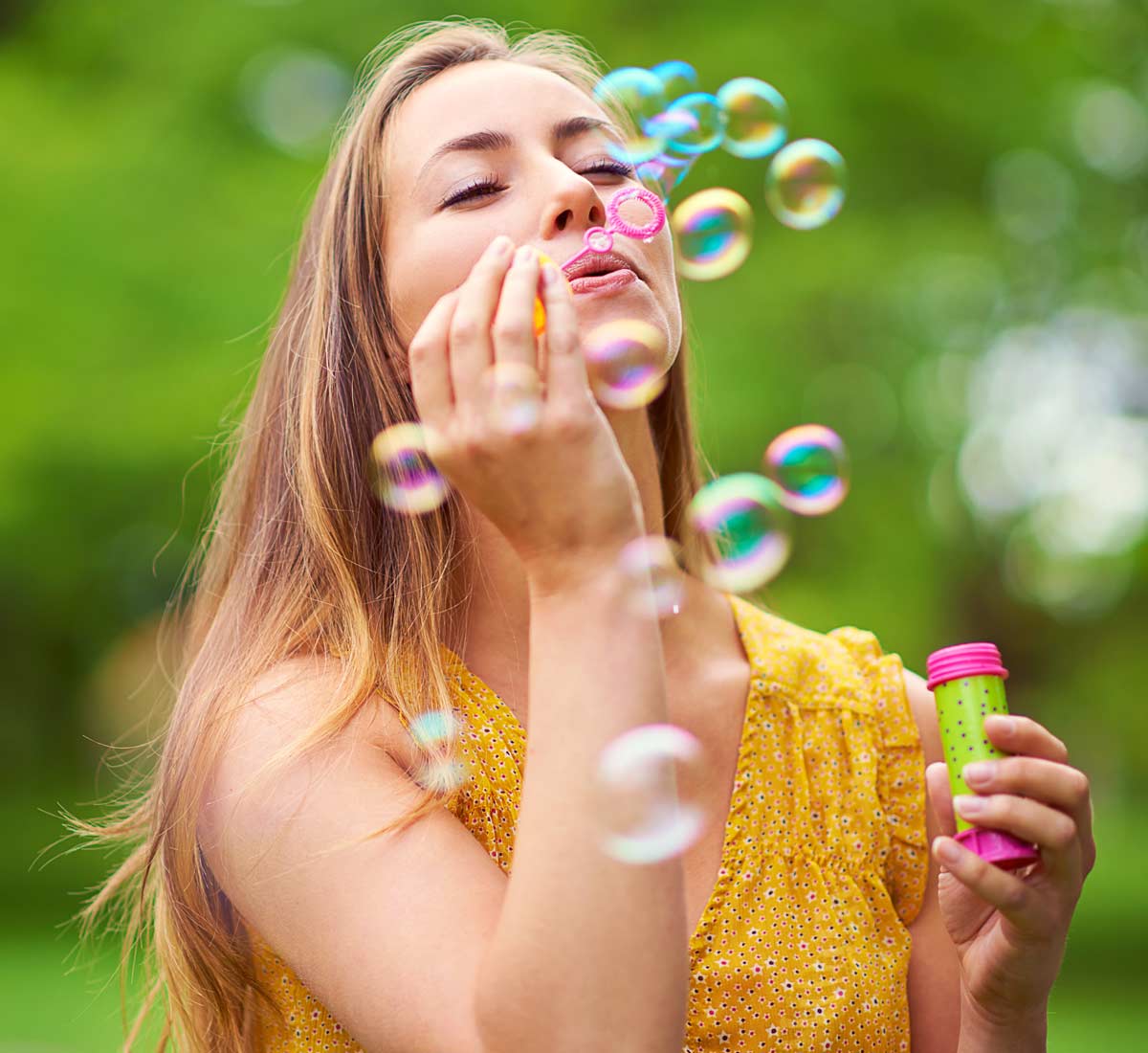 Young lady excitedly blowing bubbles