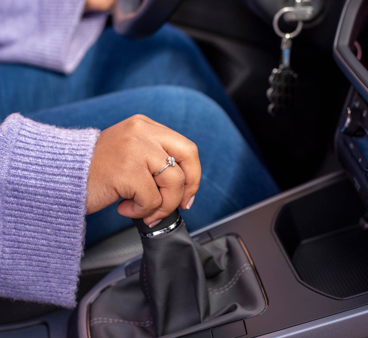 hand of female driver resting on gear stick