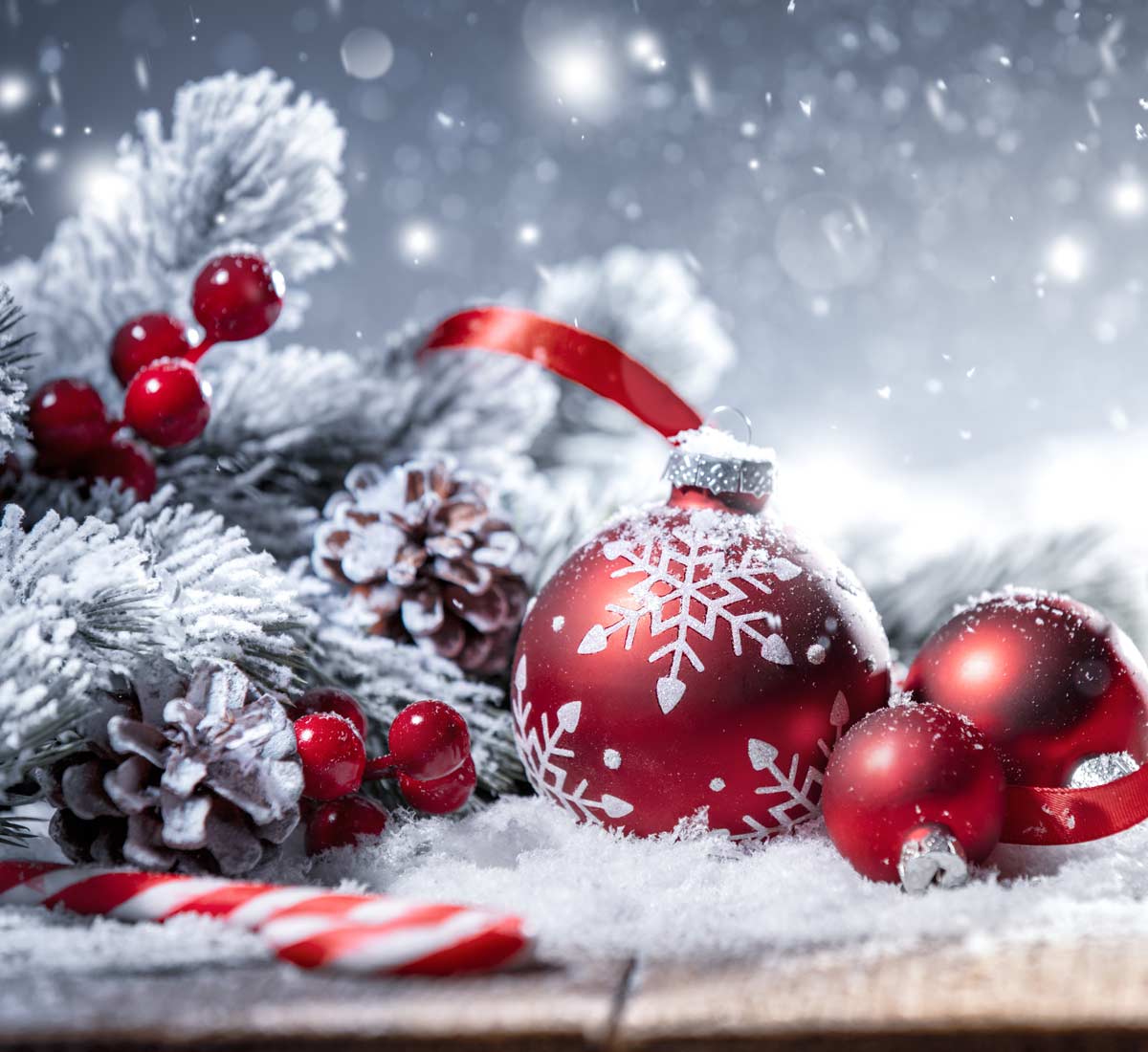 Christmas decorations up on table top, baubles and faux snow and fir tree sprigs