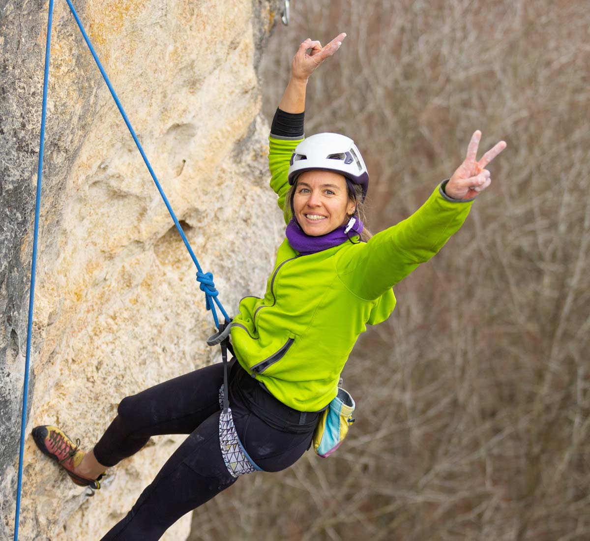 Lady mountaineer getting ready to abseil down mountain