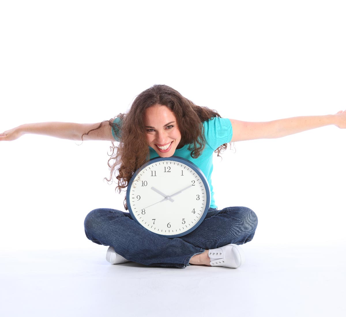 Young lady sitting cross-legged with arms outstretched with clock on lap