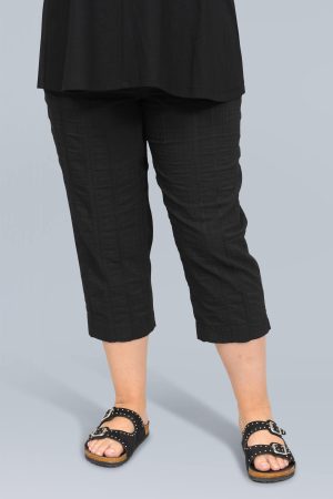 The model in this photo is wearing a pair of black K J Brand Wash & Go capri pants or pedal pushers from Bakou London for curvy girls
