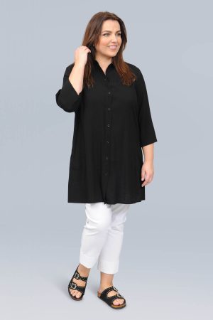 The model in this photo is wearing a fabulous long black shirt top by German designers See You with frayed edging in larger sizes for curvy girls available from Bakou London